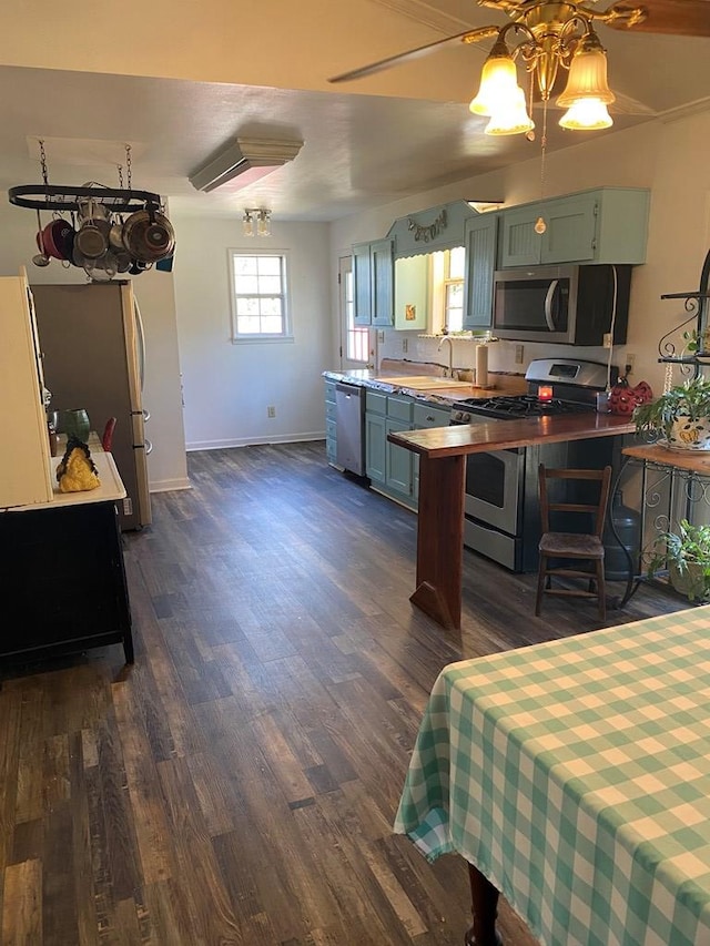 kitchen featuring sink, dark wood-type flooring, ceiling fan, appliances with stainless steel finishes, and green cabinetry