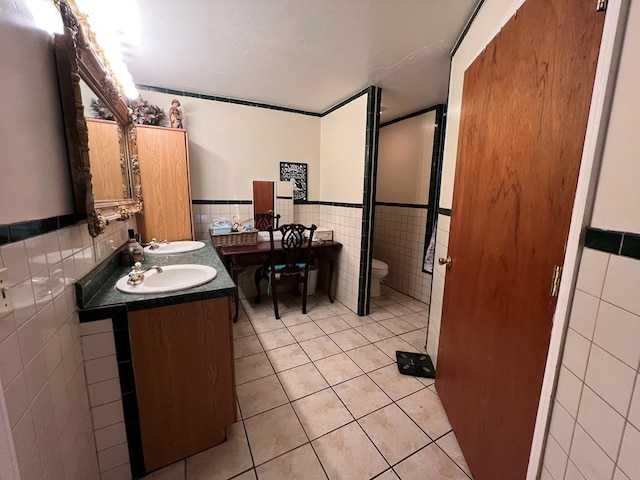 bathroom featuring tile patterned flooring, sink, and tile walls