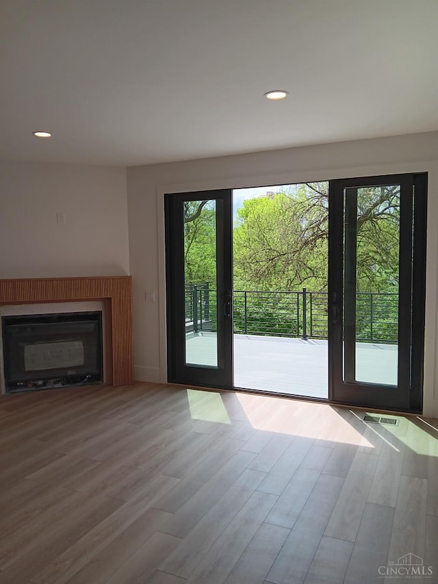 doorway featuring wood finished floors, a glass covered fireplace, and recessed lighting