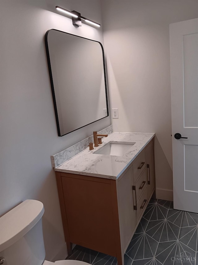 bathroom featuring vanity, toilet, and tile patterned flooring