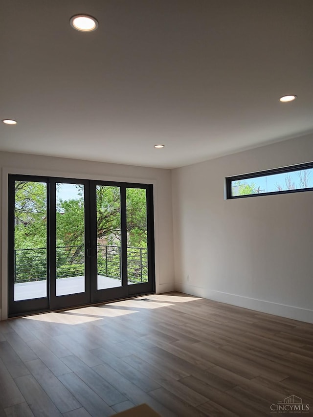 spare room featuring recessed lighting, wood finished floors, french doors, and baseboards