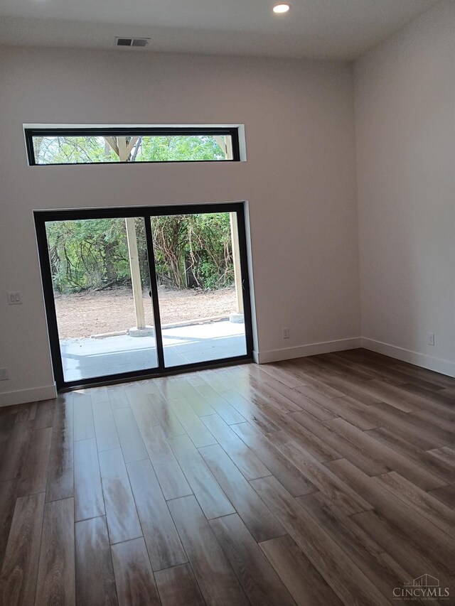 spare room with recessed lighting, dark wood-type flooring, and baseboards