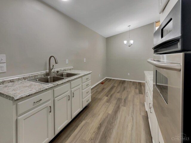 824 Cascade Rd, Forest Park, OH 45240 - kitchen featuring a sink, white cabinetry, vaulted ceiling, light wood finished floors, and oven