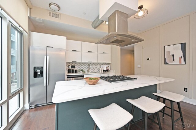 1 Mercer St Unit 204, Cincinnati, OH 45202 - kitchen with visible vents, island range hood, appliances with stainless steel finishes, dark wood finished floors, and a breakfast bar