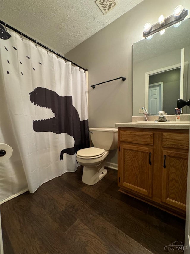 5506 Glen Ct, Carlisle, OH 45005 - bathroom featuring vanity, wood-type flooring, a textured ceiling, toilet, and a shower with shower curtain