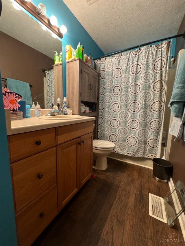 5506 Glen Ct, Carlisle, OH 45005 - full bathroom with vanity, toilet, a textured ceiling, shower / bath combo with shower curtain, and hardwood / wood-style floors