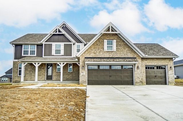 craftsman-style home with a shingled roof, concrete driveway, a porch, board and batten siding, and brick siding