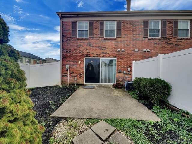 rear view of house with central AC unit and a patio area