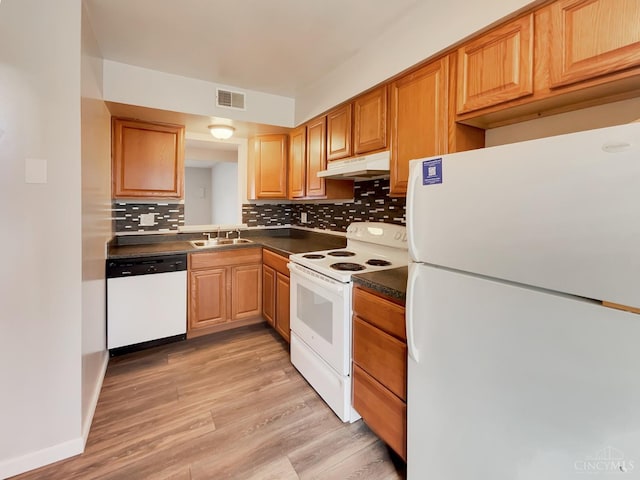 kitchen with decorative backsplash, white appliances, sink, and light hardwood / wood-style flooring