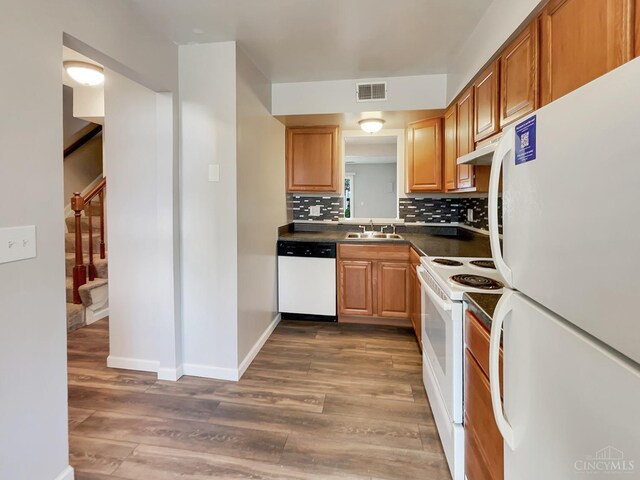 kitchen featuring dark hardwood / wood-style floors, sink, backsplash, and white appliances