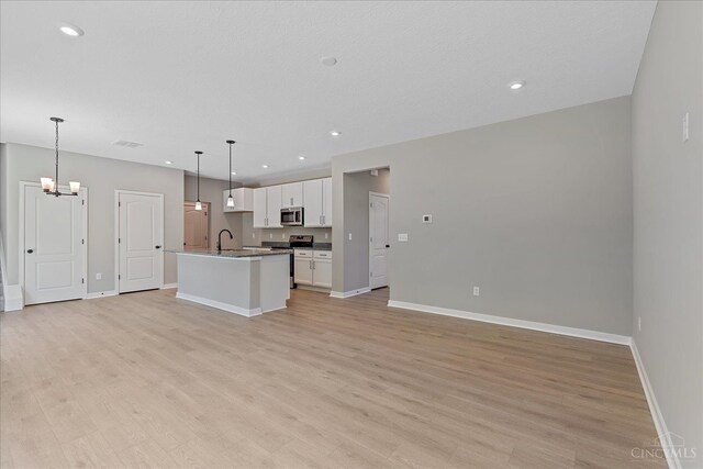 1658 Whitewater Trails Blvd, Harrison, OH 45030 - kitchen featuring appliances with stainless steel finishes, open floor plan, a sink, baseboards, and white cabinets
