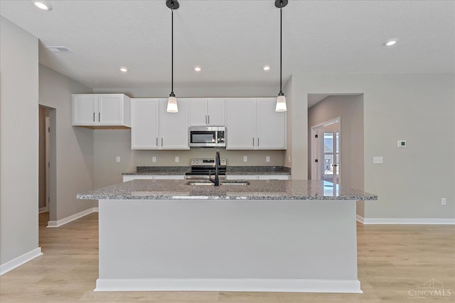 1658 Whitewater Trails Blvd, Harrison, OH 45030 - kitchen with stainless steel microwave, a sink, white cabinetry, light wood-style flooring, and a textured ceiling