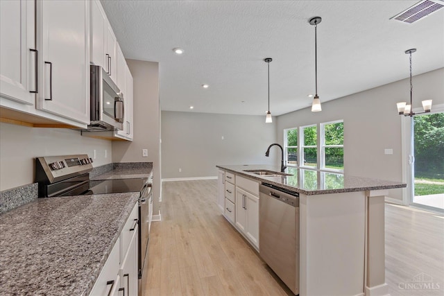 1658 Whitewater Trails Blvd, Harrison, OH 45030 - kitchen with stainless steel appliances, a sink, light wood-type flooring, an island with sink, and white cabinets
