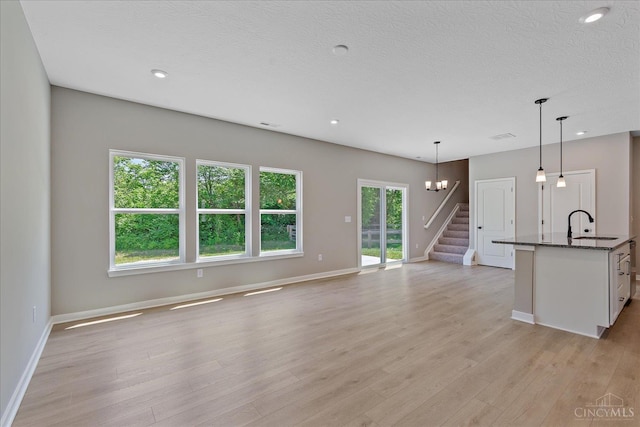 1658 Whitewater Trails Blvd, Harrison, OH 45030 - unfurnished living room with stairway, baseboards, light wood-style flooring, a sink, and recessed lighting