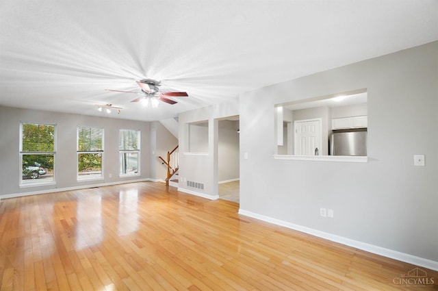 818 William Howard Taft Rd, Cincinnati, OH 45206 - unfurnished living room featuring stairway, light wood-style flooring, and a ceiling fan