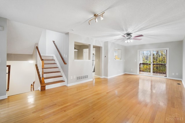 818 William Howard Taft Rd, Cincinnati, OH 45206 - unfurnished living room featuring a ceiling fan, light wood-type flooring, stairs, and a textured ceiling
