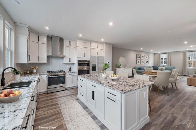 7230 Abington Way Unit 21805, West Chester, OH 45069 - kitchen with wall chimney exhaust hood, appliances with stainless steel finishes, dark wood-style floors, a kitchen island, and white cabinetry