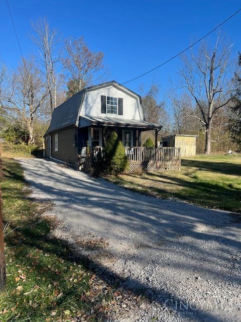 338 Wiltsee Ave, Miami Twp, OH 45140 - view of front of home with a gambrel roof, gravel driveway, and a porch
