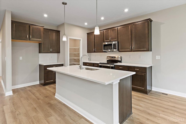 4517 Renaissance Park Dr, Middletown, OH 45005 - kitchen with appliances with stainless steel finishes, a sink, dark brown cabinetry, light wood-type flooring, and recessed lighting