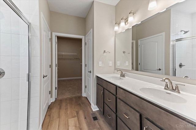 4517 Renaissance Park Dr, Middletown, OH 45005 - bathroom with a shower stall, double vanity, wood finished floors, a walk in closet, and baseboards
