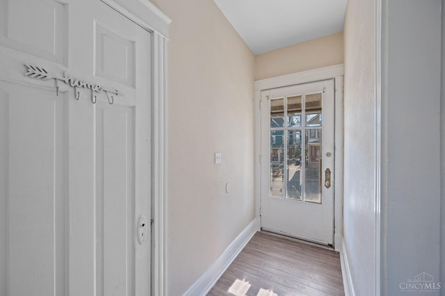 doorway to outside with baseboards and wood finished floors