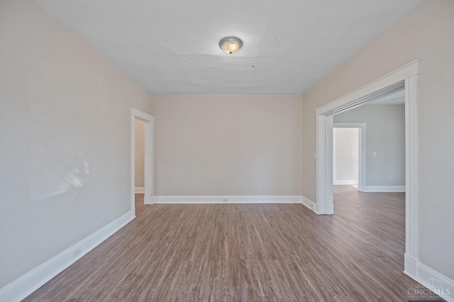 unfurnished room with wood finished floors and baseboards
