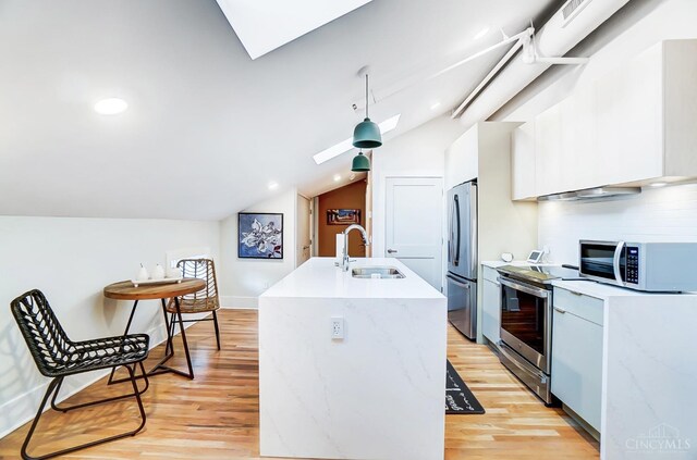 kitchen featuring white cabinetry, sink, light hardwood / wood-style floors, lofted ceiling, and appliances with stainless steel finishes