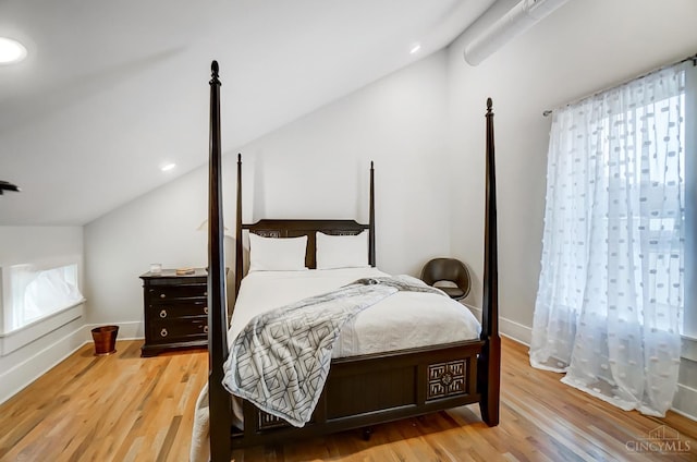 bedroom with light hardwood / wood-style floors, multiple windows, and lofted ceiling