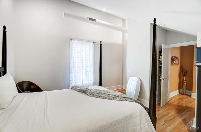 bedroom featuring light hardwood / wood-style floors and vaulted ceiling