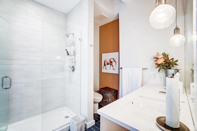 bathroom with toilet, an enclosed shower, and vanity