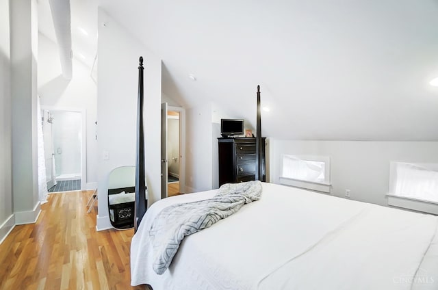 bedroom with light hardwood / wood-style floors and lofted ceiling