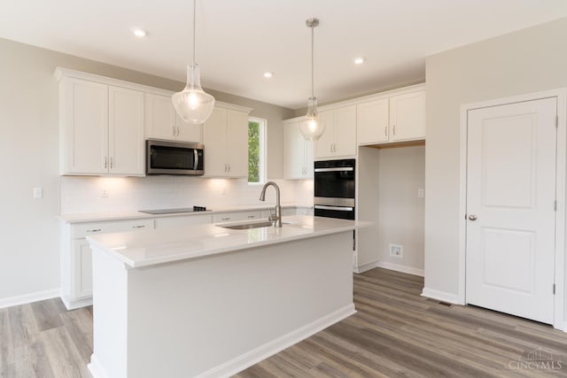 4147 Amelia Olive Branch Rd, Batavia Twp, OH 45103 - kitchen featuring stainless steel microwave, a sink, multiple ovens, white cabinets, and backsplash