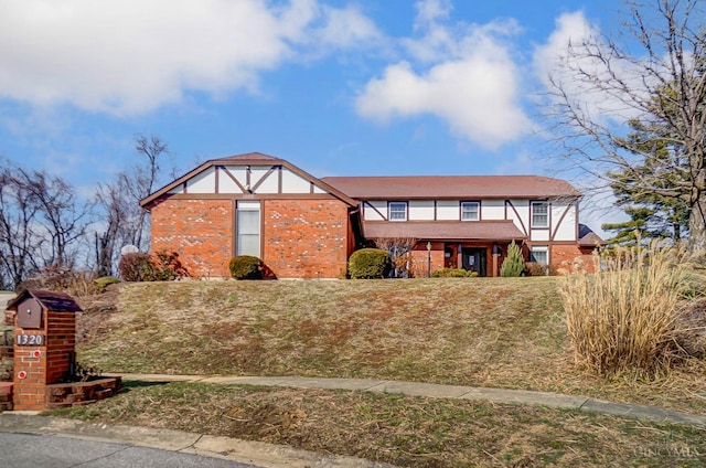 tudor house featuring brick siding