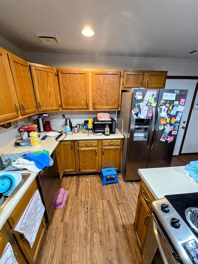 kitchen with light wood-type flooring and appliances with stainless steel finishes