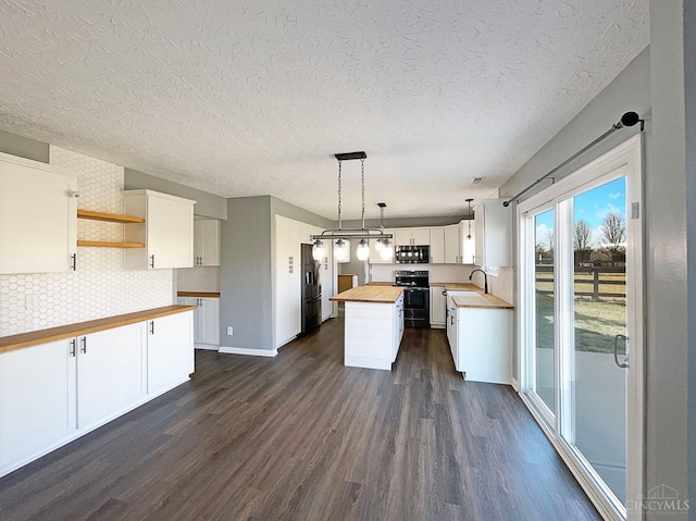 1789 Greentree Meadows Dr, Turtle Creek Twp, OH 45036 - kitchen featuring white cabinets, wooden counters, appliances with stainless steel finishes, hanging light fixtures, and a center island