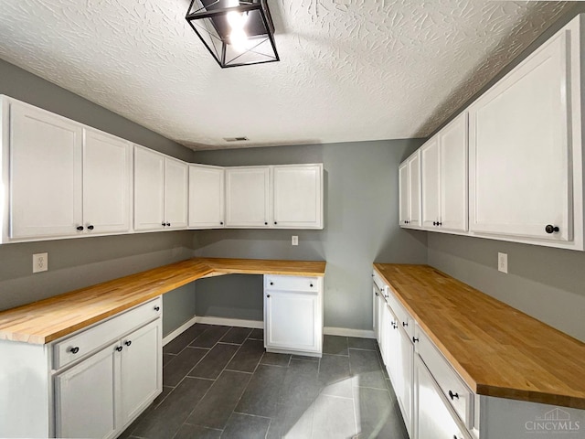 1789 Greentree Meadows Dr, Turtle Creek Twp, OH 45036 - kitchen with white cabinets, wooden counters, built in desk, and baseboards
