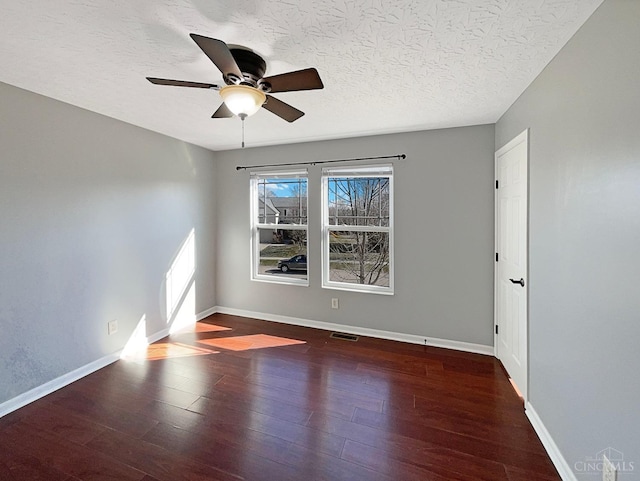 1789 Greentree Meadows Dr, Turtle Creek Twp, OH 45036 - empty room with baseboards, visible vents, a ceiling fan, dark wood-style floors, and a textured ceiling
