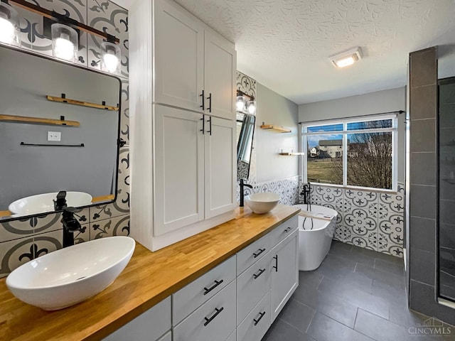 1789 Greentree Meadows Dr, Turtle Creek Twp, OH 45036 - full bathroom with double vanity, tile patterned floors, a freestanding bath, a textured ceiling, and a sink