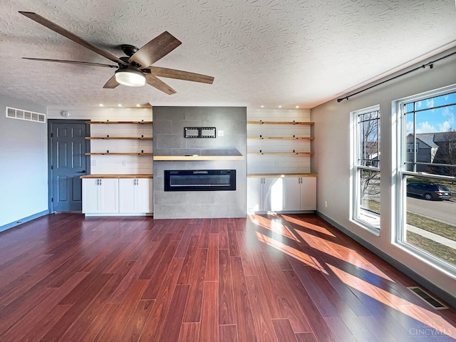 1789 Greentree Meadows Dr, Turtle Creek Twp, OH 45036 - unfurnished living room featuring dark wood-style floors, a large fireplace, visible vents, and a textured ceiling