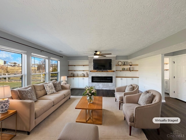 1789 Greentree Meadows Dr, Turtle Creek Twp, OH 45036 - living area featuring light wood-style floors, a fireplace, a textured ceiling, and a ceiling fan