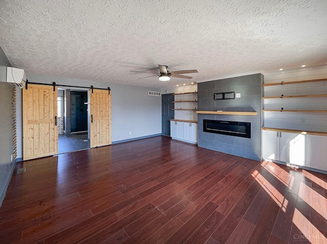 1789 Greentree Meadows Dr, Turtle Creek Twp, OH 45036 - unfurnished living room featuring a barn door, a ceiling fan, dark wood-type flooring, a textured ceiling, and a fireplace