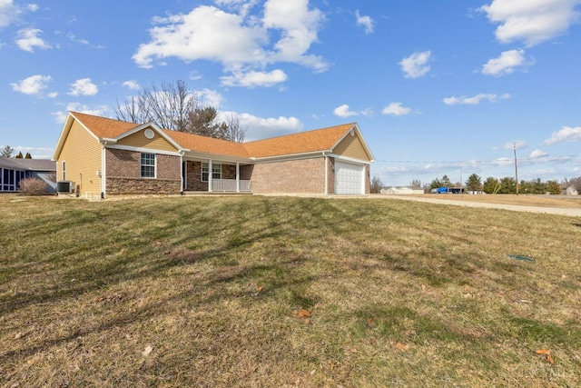 single story home with an attached garage, central air condition unit, covered porch, brick siding, and a front lawn