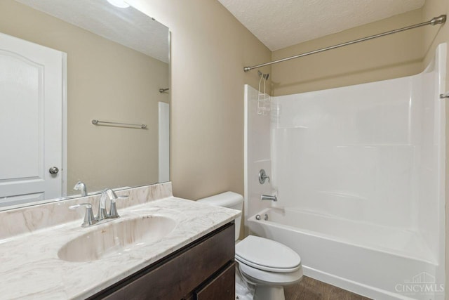 bathroom with shower / bathtub combination, toilet, a textured ceiling, vanity, and wood finished floors