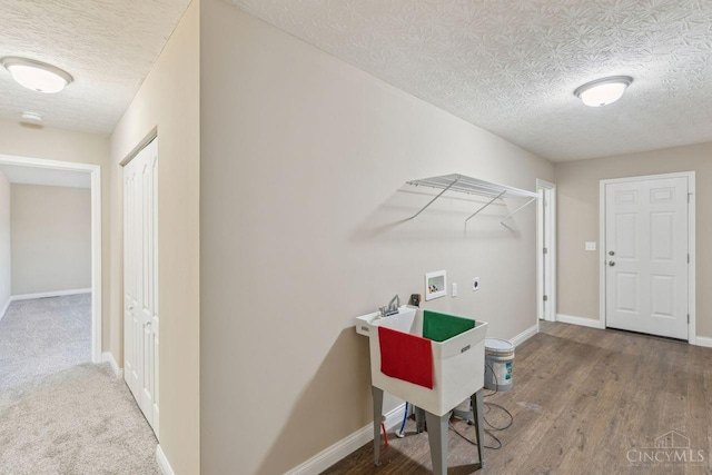 laundry area featuring washer hookup, electric dryer hookup, wood finished floors, laundry area, and baseboards