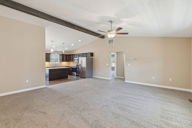 unfurnished living room featuring visible vents, lofted ceiling with beams, carpet flooring, ceiling fan, and baseboards