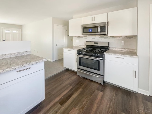 3044 Aries Ct, Colerain Twp, OH 45251 - kitchen featuring appliances with stainless steel finishes, dark wood finished floors, white cabinets, backsplash, and light stone counters