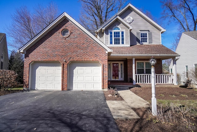 traditional-style house featuring a garage, a shingled roof, aphalt driveway, covered porch, and brick siding