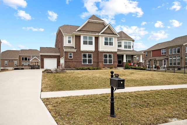 craftsman house featuring driveway, brick siding, a front lawn, a garage, and a residential view