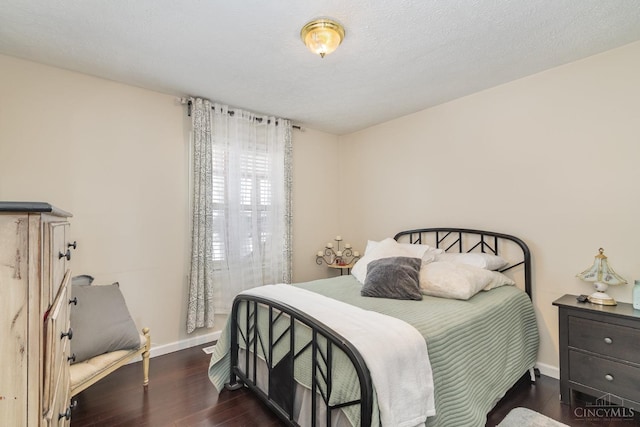 bedroom with wood finished floors and baseboards