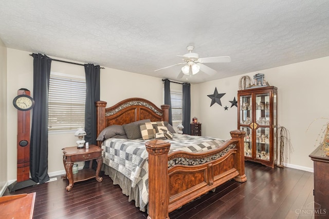 bedroom featuring dark wood-type flooring, a textured ceiling, baseboards, and a ceiling fan